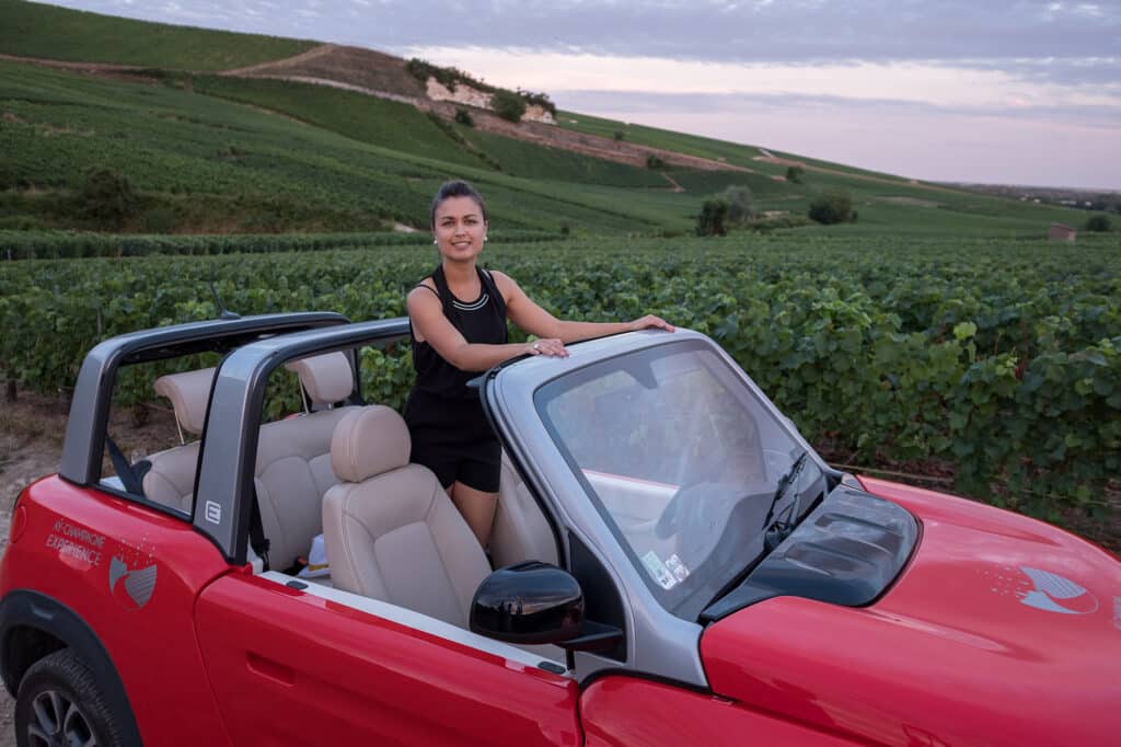 Jeune femme en décapotable dans un vignoble - Epernay Tourisme
